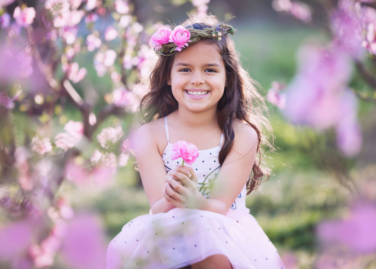 Girl seated among pink blossoms