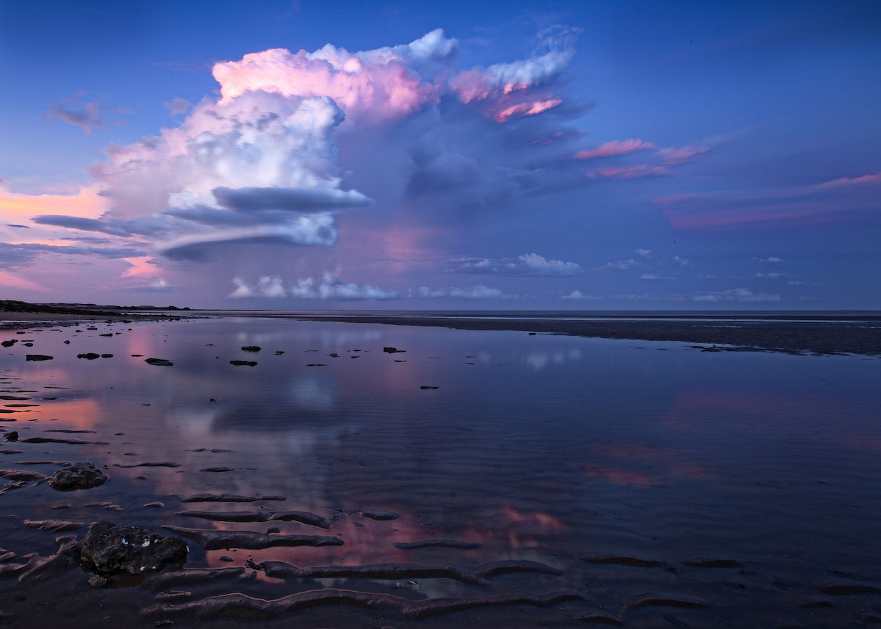 Storm clouds glowing above the coast