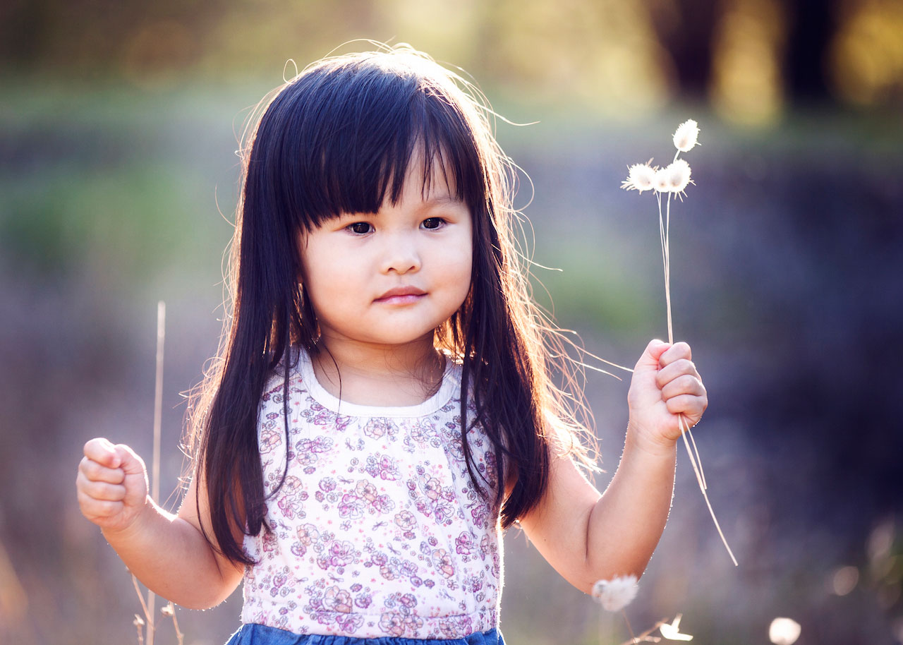 Little girl holding dandelions