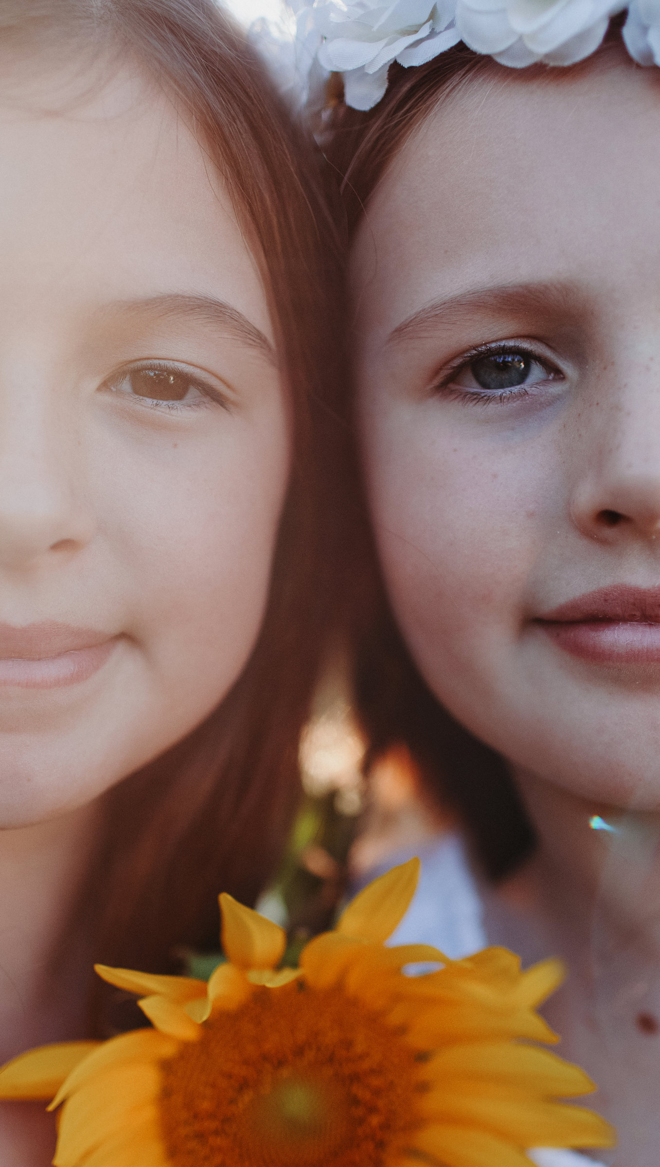 Close portrait of two children with a sunflower