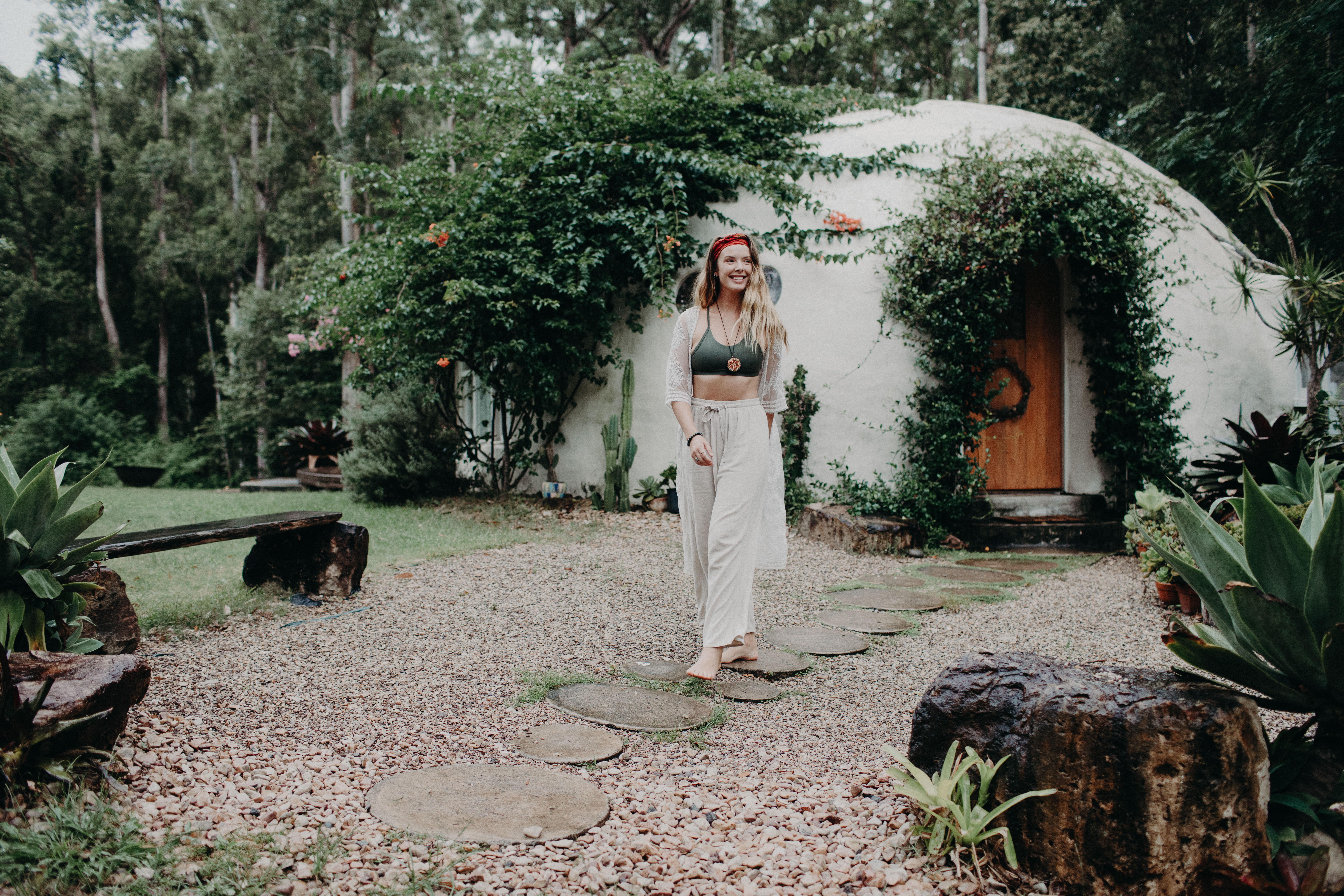 A woman walking along the garden path in front of the Wonderdome studio
